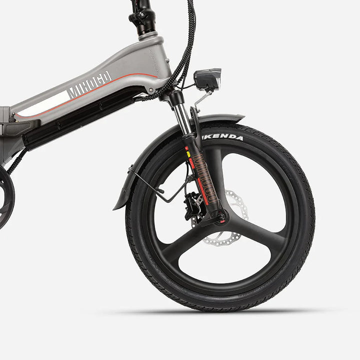 Переднее колесо серебристого электрического велосипеда Smartworld с покрышкой Kenda и дисковым тормозом.